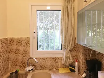 a kitchen with a sink and a window at La Vie En Rose Studio,close to beach, Paleo Faliro in Athens