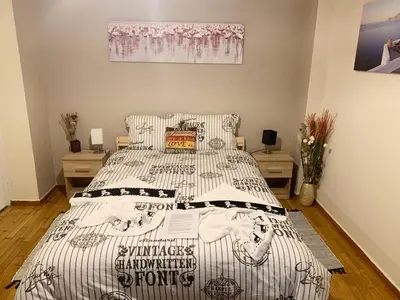 a bedroom with a bed with a black and white comforter at La Vie En Rose Studio,close to beach, Paleo Faliro in Athens