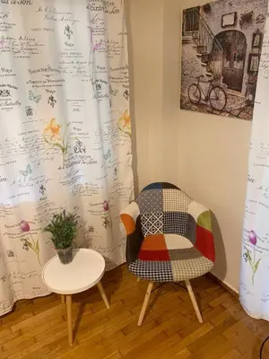 a chair and a table in a room at La Vie En Rose Studio,close to beach, Paleo Faliro in Athens