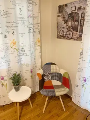 a chair and a table with a quilt on a wall at La Vie En Rose Studio,close to beach, Paleo Faliro in Athens