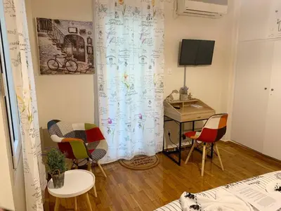 a room with a table and chairs and a desk at La Vie En Rose Studio,close to beach, Paleo Faliro in Athens