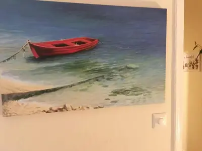 a painting of a red boat in the water at La Vie En Rose Studio,close to beach, Paleo Faliro in Athens