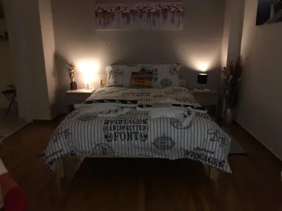 a bedroom with a bed with a black and white comforter at La Vie En Rose Studio,close to beach, Paleo Faliro in Athens