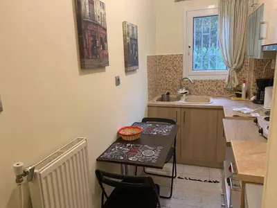 a kitchen with a table and chairs and a sink at La Vie En Rose Studio,close to beach, Paleo Faliro in Athens
