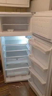 a white refrigerator with its door open with its empty shelves at Koukaki apartment near Acropolis in Athens
