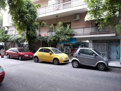 a group of three cars parked on the side of a street at Koukaki apartment near Acropolis in Athens