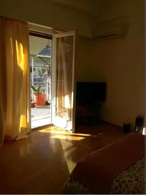 a living room with a sliding glass door to a patio at Zizi room in Athens