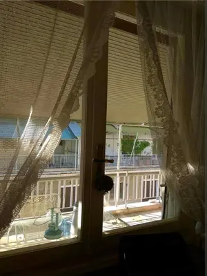 a window with curtains and a view of a balcony at Zizi room in Athens