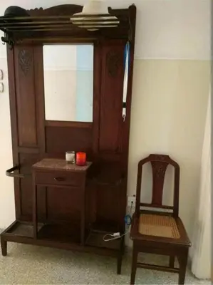 a wooden cabinet and a chair in a room at Zizi room in Athens