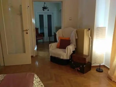 a living room with a chair and a lamp at Zizi room in Athens
