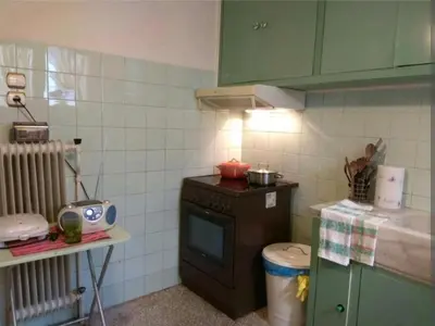 a small kitchen with a stove and green cabinets at Zizi room in Athens