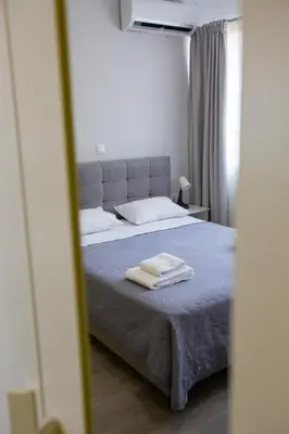 a bedroom with a bed with two towels on it at Raise Boutique Rooms in the Center of Athens in Athens