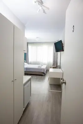 a bedroom with a bed and a desk and a tv at Raise Boutique Rooms in the Center of Athens in Athens