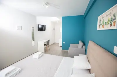 a room with a bed and a blue wall at Raise Boutique Rooms in the Center of Athens in Athens