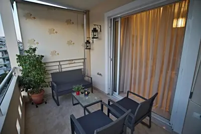 a balcony with chairs and a table and a window at Charming Apartment near Athens Center and the Sea in Athens