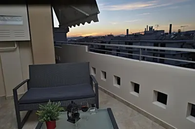a chair sitting on a balcony with a table at Charming Apartment near Athens Center and the Sea in Athens