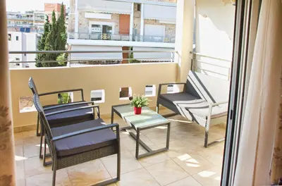 a balcony with chairs and a table and a window at Charming Apartment near Athens Center and the Sea in Athens
