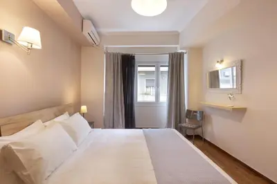 a bedroom with a large white bed and a window at Prime Location 2 BR APT next to the Acropolis in Athens