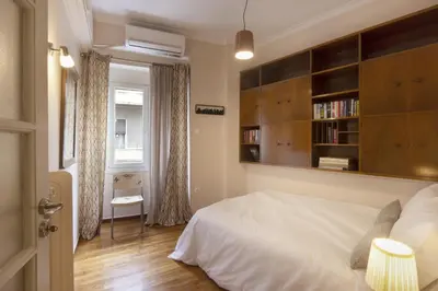 a bedroom with a bed and a book shelf at Prime Location 2 BR APT next to the Acropolis in Athens