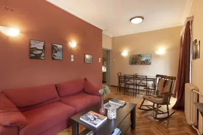a living room with a red couch and a table at Prime Location 2 BR APT next to the Acropolis in Athens