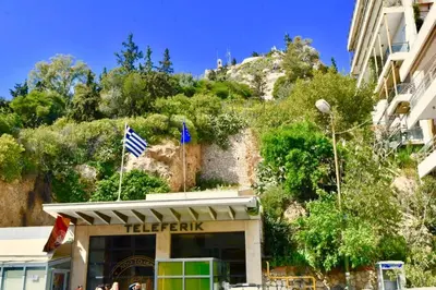 a building with a flag on top of it with a mountain at Kolonaki Spacious 1 Bd Apt with Outdoor Patio in Athens