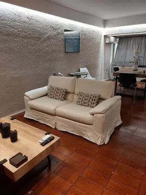 a living room with a white couch and a table at Kolonaki Spacious 1 Bd Apt with Outdoor Patio in Athens