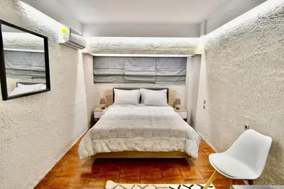 a small bedroom with a bed and a chair at Kolonaki Spacious 1 Bd Apt with Outdoor Patio in Athens