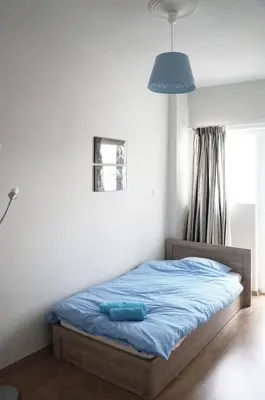 a bedroom with a bed with a blue sheets and a blue lamp at Comfy Apartment With Acropolis View in Athens