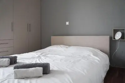 a bedroom with a white bed with two towels on it at Comfy Apartment With Acropolis View in Athens