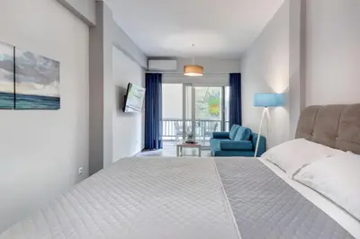a bedroom with a white bed and a blue chair at Brand new apartment in the heart of the city in Athens