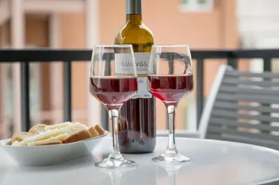 two glasses of wine on a table with a bottle of wine at Brand new apartment in the heart of the city in Athens