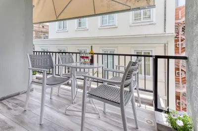 a balcony with chairs and a table and an umbrella at Brand new apartment in the heart of the city in Athens