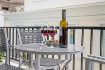 a bottle of wine and two glasses on a table at Brand new apartment in the heart of the city in Athens