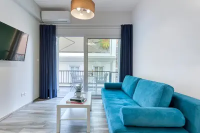 a living room with a blue couch and a table at Brand new apartment in the heart of the city in Athens