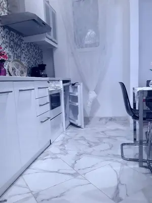 a kitchen with white appliances and a table with a chair at Αnna's Home 2 .Holidays in beautiful Athens in Athens