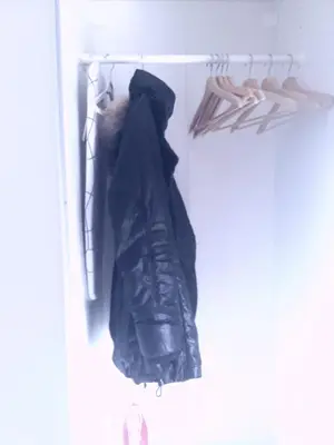 a black jacket hanging on a rack in a closet at Αnna's Home 2 .Holidays in beautiful Athens in Athens