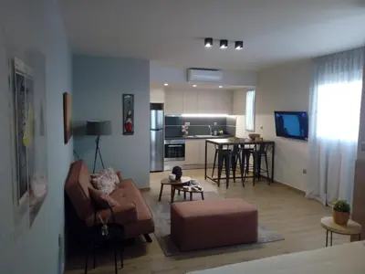 a living room with a couch and a kitchen at Beautiful studio next to ancient stadium in Athens