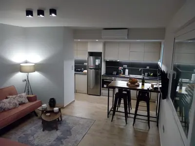 a kitchen and living room with a table and a couch at Beautiful studio next to ancient stadium in Athens