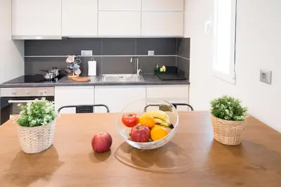 a bowl of fruit on a wooden table in a kitchen at Beautiful studio next to ancient stadium in Athens