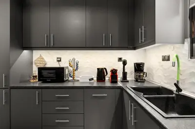 a kitchen with black cabinets and a sink at Luxury apartment in Glyfada(near metro station)C82 in Athens