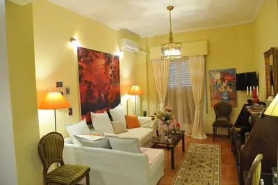 a living room with a white couch and a table at Cozy ACROPOLIS in Athens
