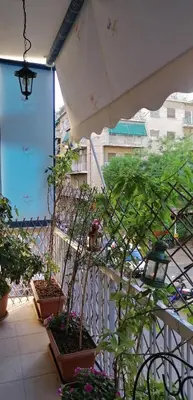 a balcony with potted plants and a white railing at Cozy ACROPOLIS in Athens