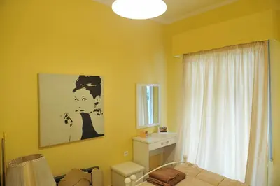 a yellow room with a bed and a window at Cozy ACROPOLIS in Athens