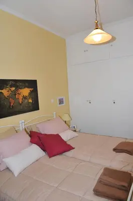 a bedroom with two beds with red and white pillows at Cozy ACROPOLIS in Athens