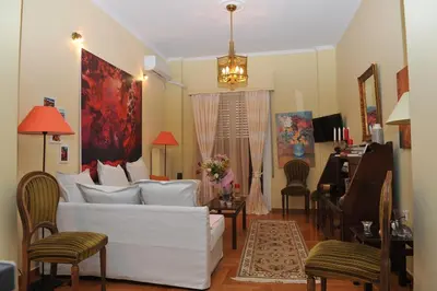 a living room with a white couch and a piano at Cozy ACROPOLIS in Athens