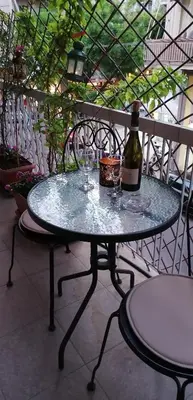 a glass table with a bottle of wine on it at Cozy ACROPOLIS in Athens