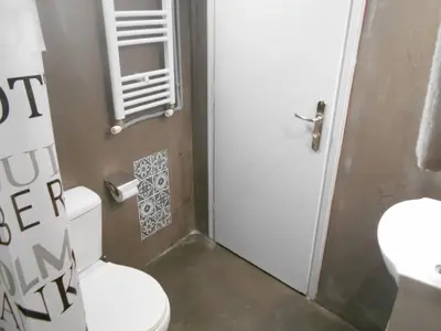 a bathroom with a toilet and a white door at Koukaki-close to Acropolis(Stone apartment) in Athens