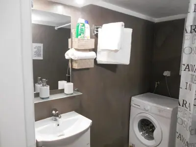 a bathroom with a washing machine and a sink at Koukaki-close to Acropolis(Stone apartment) in Athens