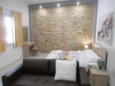 a bedroom with a couch and a stone wall at Koukaki-close to Acropolis(Stone apartment) in Athens