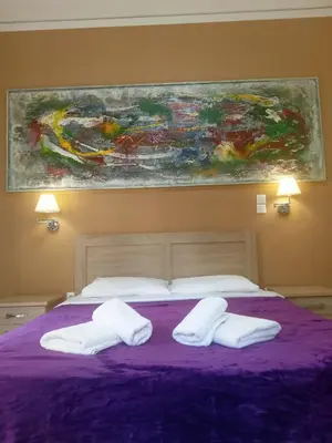 a bedroom with a purple bed with two white pillows at Koukaki-Acropolis roomy with a private veranda apt. in Athens